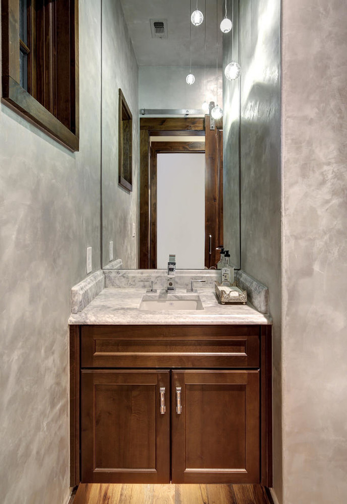Inspiration for a small transitional powder room in Austin with recessed-panel cabinets, medium wood cabinets, grey walls, medium hardwood floors, an undermount sink, engineered quartz benchtops, multi-coloured floor and grey benchtops.
