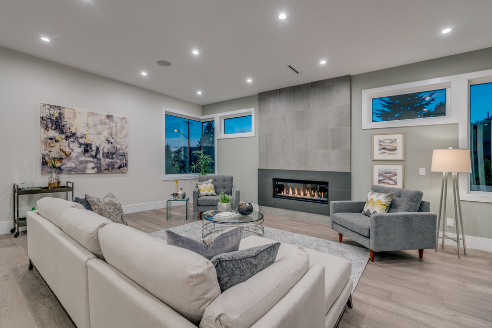 Design ideas for a contemporary formal open concept living room in Vancouver with white walls, laminate floors, a standard fireplace, a tile fireplace surround, a built-in media wall and grey floor.