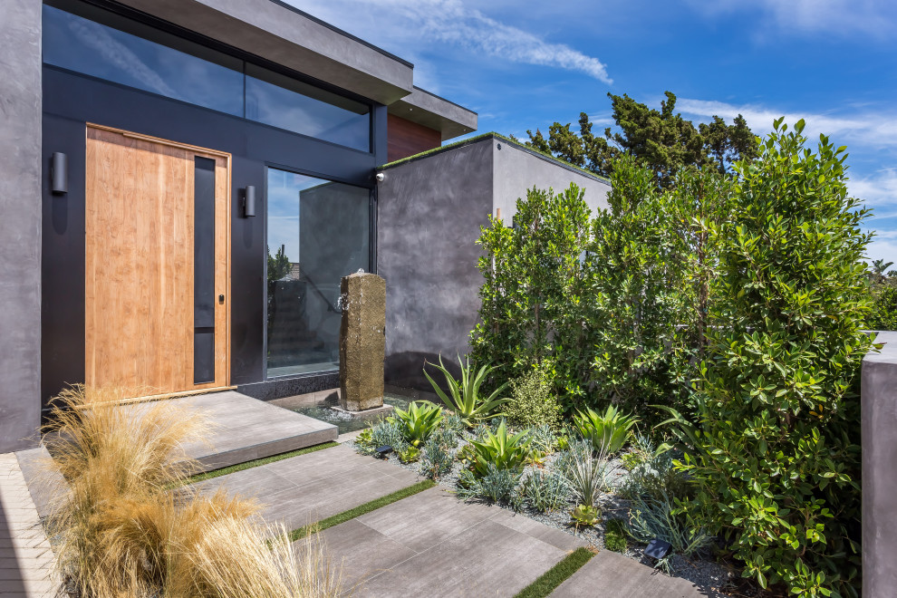 Inspiration for a large contemporary gray two-story concrete exterior home remodel in Los Angeles with a green roof