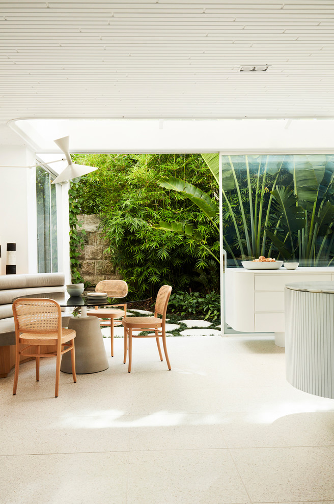 This is an example of a modern dining room in Sydney with white walls and white floor.