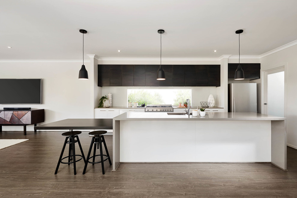 This is an example of a mid-sized contemporary single-wall eat-in kitchen in Melbourne with flat-panel cabinets, stainless steel appliances, medium hardwood floors, with island and an undermount sink.