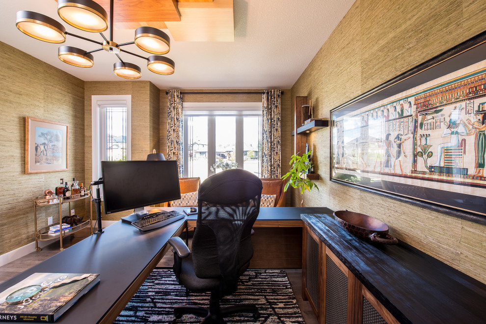 Inspiration for a mid-sized transitional study room in Edmonton with green walls, medium hardwood floors, a freestanding desk, brown floor, wood and wallpaper.