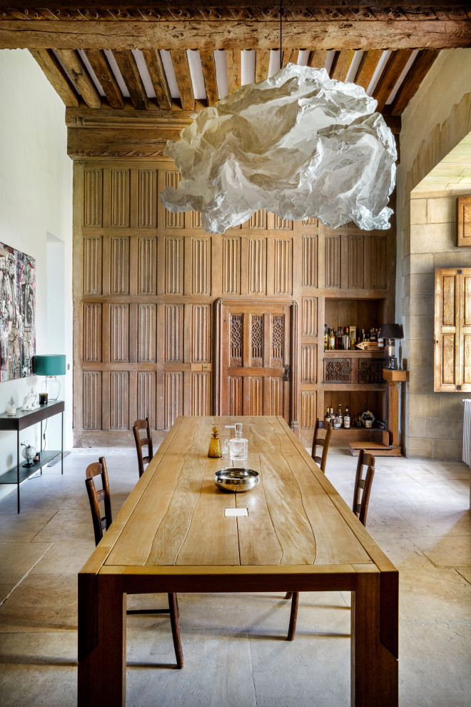 Photo of a contemporary dining room in Other with brown walls, beige floors, exposed beams and wainscoting.