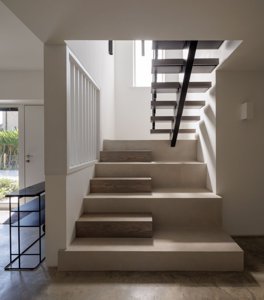 На фото: бетонная лестница на больцах в современном стиле с деревянными ступенями и металлическими перилами