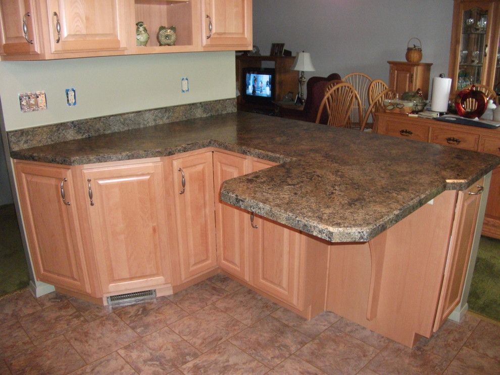 Kitchen - traditional vinyl floor kitchen idea with a drop-in sink, raised-panel cabinets, light wood cabinets, laminate countertops, green backsplash and white appliances