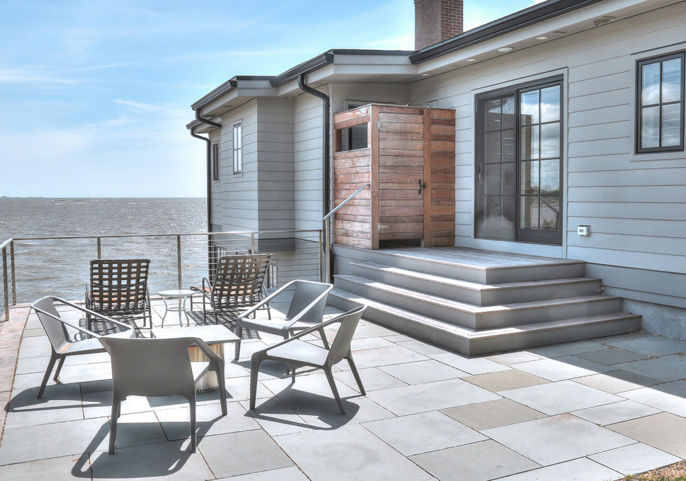 Modelo de terraza planta baja escandinava de tamaño medio sin cubierta en patio trasero con ducha exterior y barandilla de cable