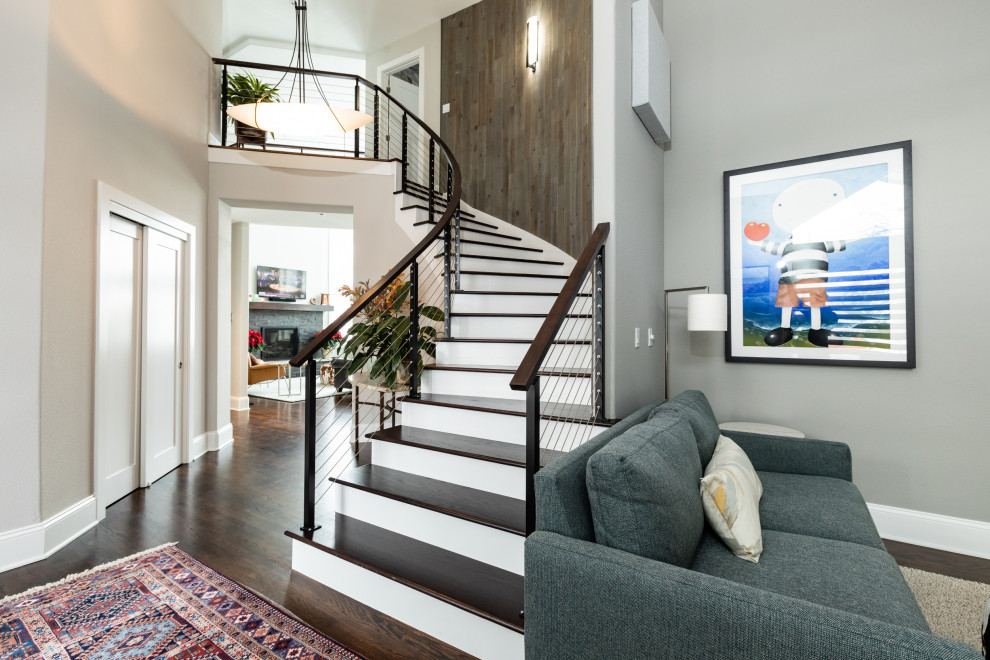 Photo of a contemporary wood curved staircase in Denver with painted wood risers and cable railing.