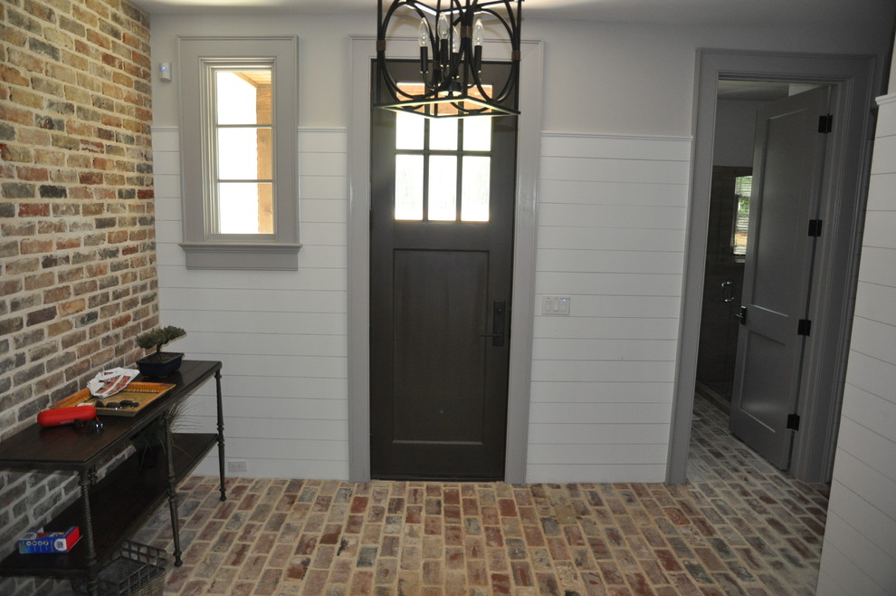 Example of a mid-sized transitional brick floor and multicolored floor mudroom design with white walls and a dark wood front door