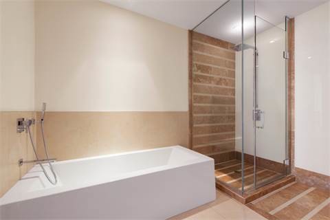 This is an example of a large modern master bathroom in Chicago with raised-panel cabinets, brown cabinets, a freestanding tub, an open shower, a two-piece toilet, multi-coloured tile, porcelain tile, beige walls, porcelain floors, a vessel sink, engineered quartz benchtops and beige floor.