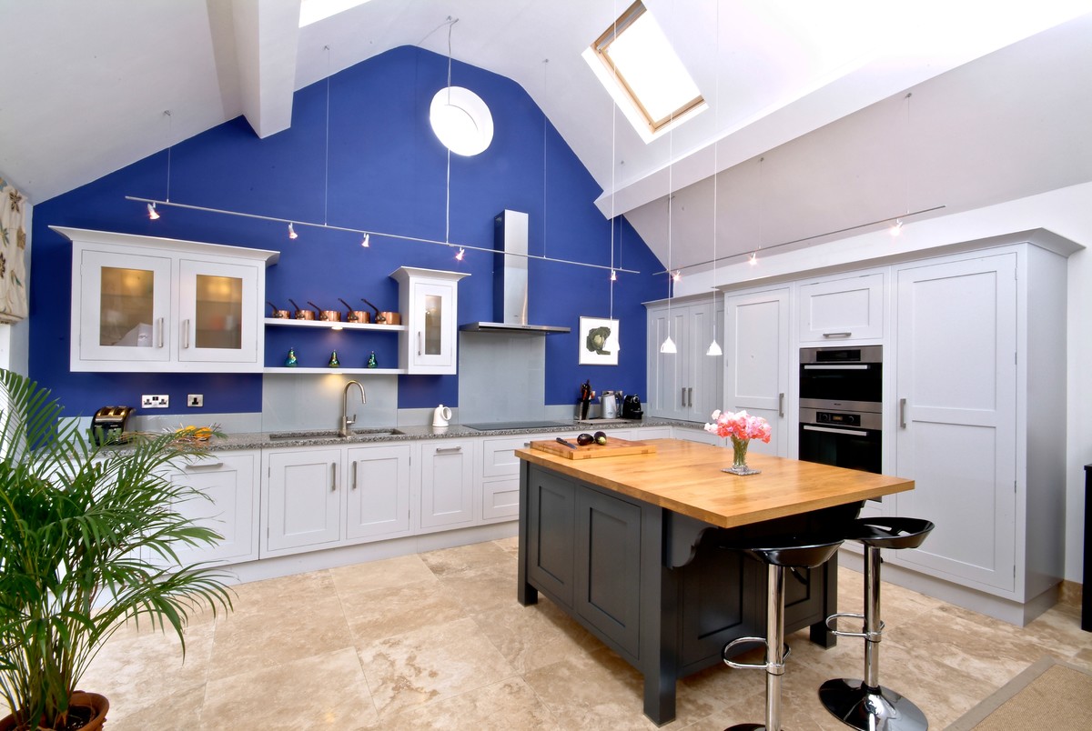 Large contemporary l-shaped kitchen in Hampshire with a double-bowl sink, grey cabinets, grey splashback, integrated appliances, a breakfast bar and beige floors.