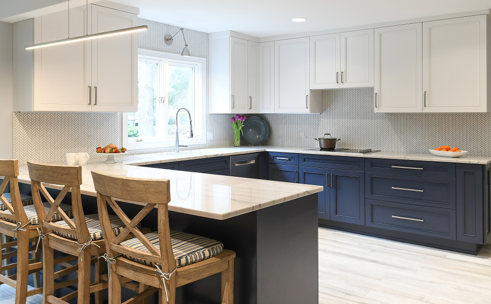This is an example of a large beach style u-shaped kitchen in Atlanta with an undermount sink, flat-panel cabinets, white cabinets, solid surface benchtops, white splashback, porcelain splashback, stainless steel appliances, porcelain floors, a peninsula, grey floor and multi-coloured benchtop.