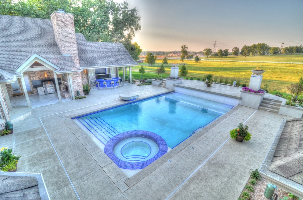 Large transitional backyard concrete paver and rectangular natural hot tub photo in Cedar Rapids