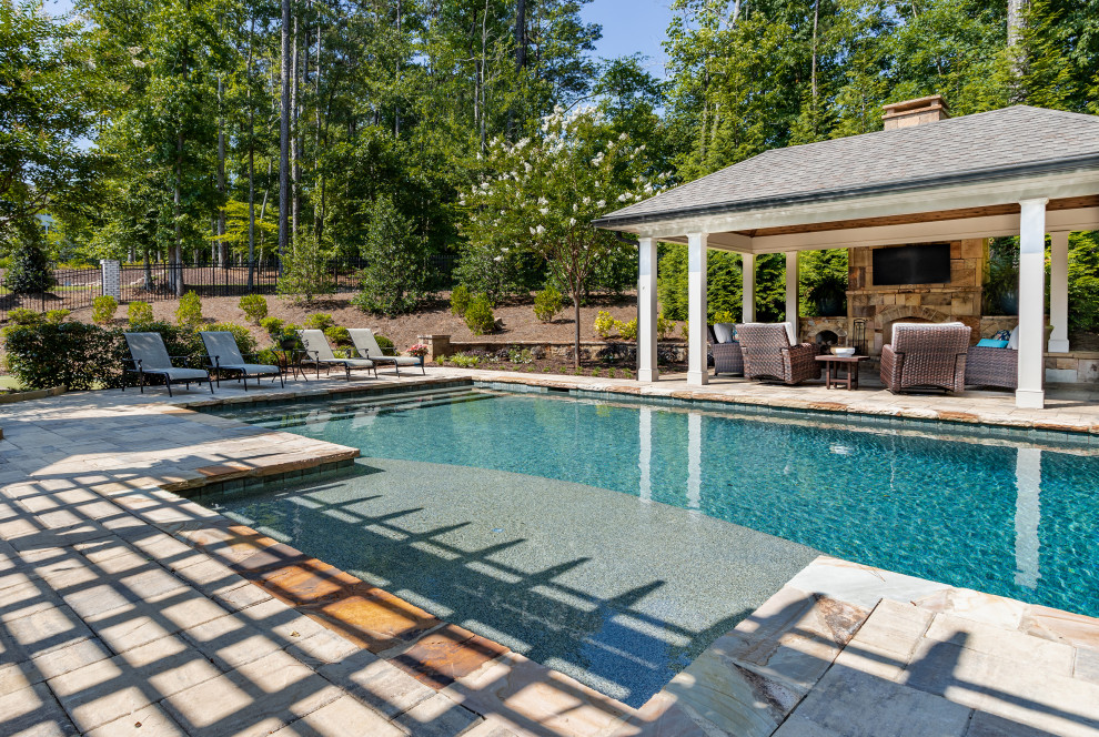 Imagen de casa de la piscina y piscina natural clásica grande rectangular en patio trasero con adoquines de piedra natural