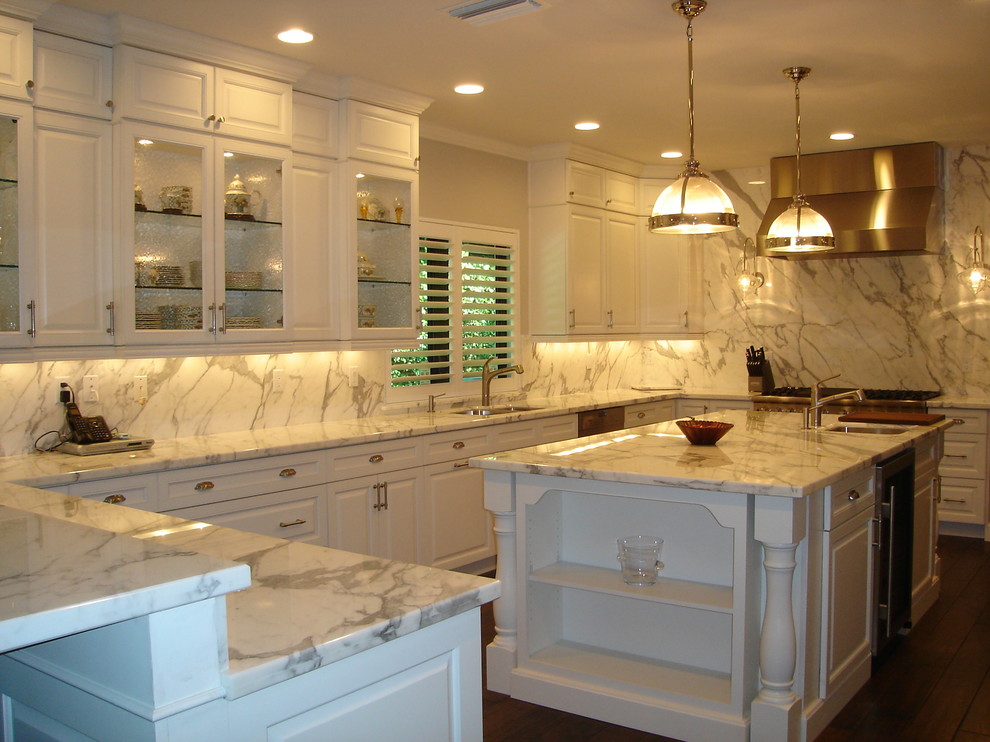 Inspiration for a large transitional u-shaped dark wood floor eat-in kitchen remodel in Miami with raised-panel cabinets, white cabinets, an island, an undermount sink, marble countertops, white backsplash, stone slab backsplash and stainless steel appliances