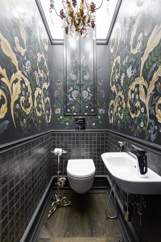 This is an example of an eclectic powder room in Moscow with a wall-mount toilet, black tile, black walls, brown floor and a wall-mount sink.