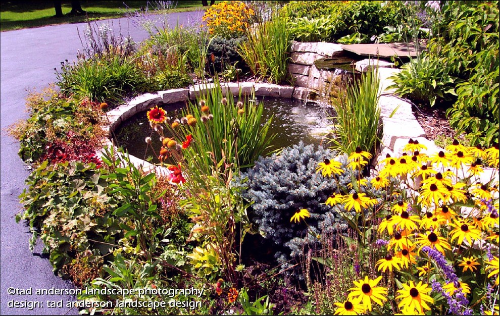 This is an example of a traditional full sun front yard stone water fountain landscape in Minneapolis for summer.