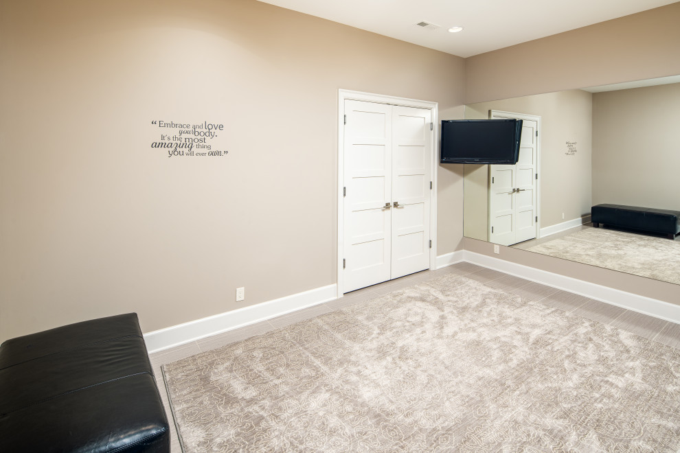 Photo of a mid-sized traditional home weight room in Omaha with beige walls, porcelain floors and grey floor.