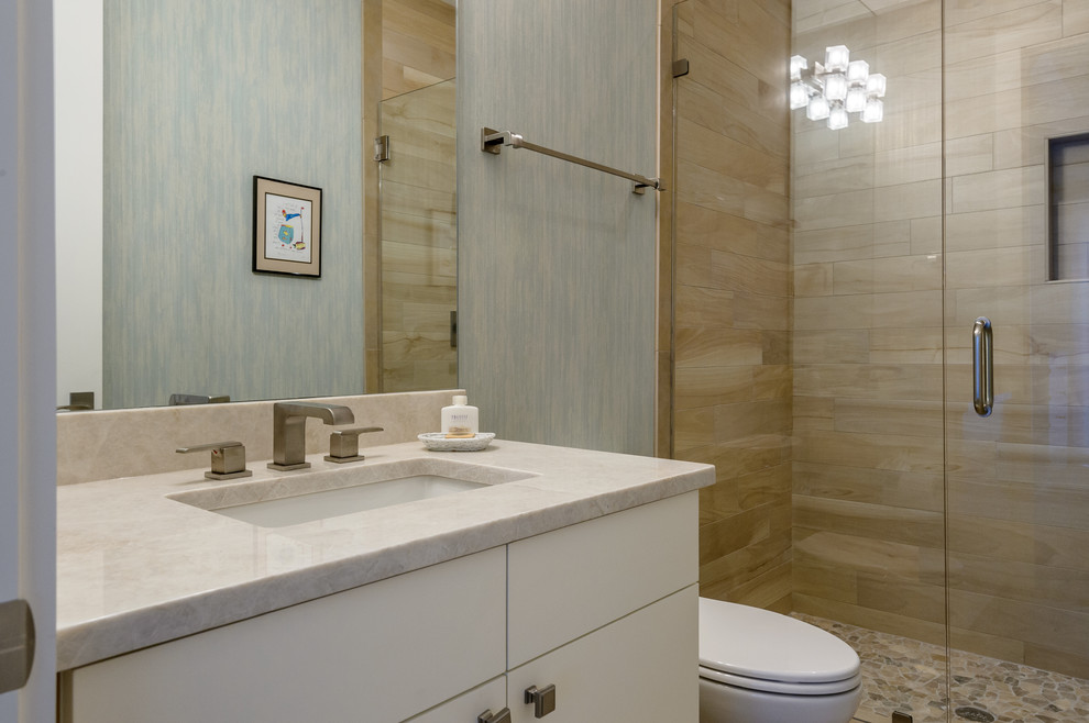 Inspiration for a mid-sized contemporary 3/4 bathroom in Charleston with flat-panel cabinets, beige tile, porcelain tile, quartzite benchtops, an alcove shower, a one-piece toilet, an undermount sink, a hinged shower door, white cabinets, brown walls, light hardwood floors and beige floor.