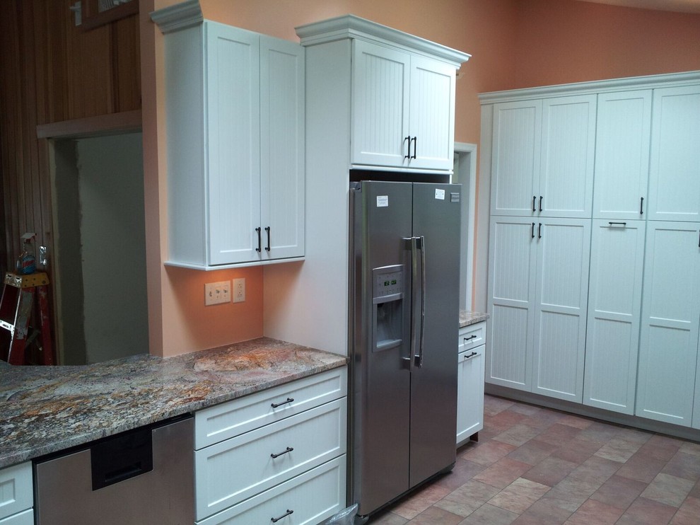 Photo of a mid-sized arts and crafts u-shaped separate kitchen in Philadelphia with an undermount sink, shaker cabinets, white cabinets, laminate benchtops, stainless steel appliances, ceramic floors, a peninsula and red floor.