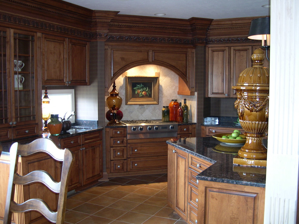 Inspiration for a large traditional eat-in kitchen in Cleveland with raised-panel cabinets, dark wood cabinets, granite benchtops, grey splashback, ceramic splashback, stainless steel appliances, ceramic floors, with island and an undermount sink.