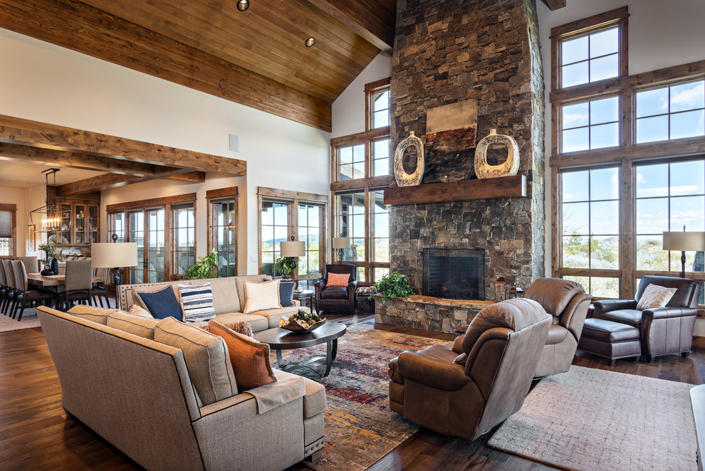 Design ideas for a country formal open concept living room in Other with white walls, dark hardwood floors, a standard fireplace, a stone fireplace surround and no tv.