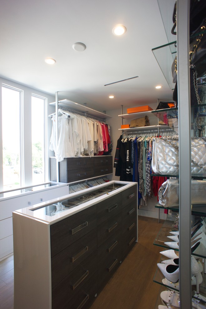 Inspiration for a mid-sized modern gender-neutral walk-in wardrobe in Miami with open cabinets, dark wood cabinets and medium hardwood floors.