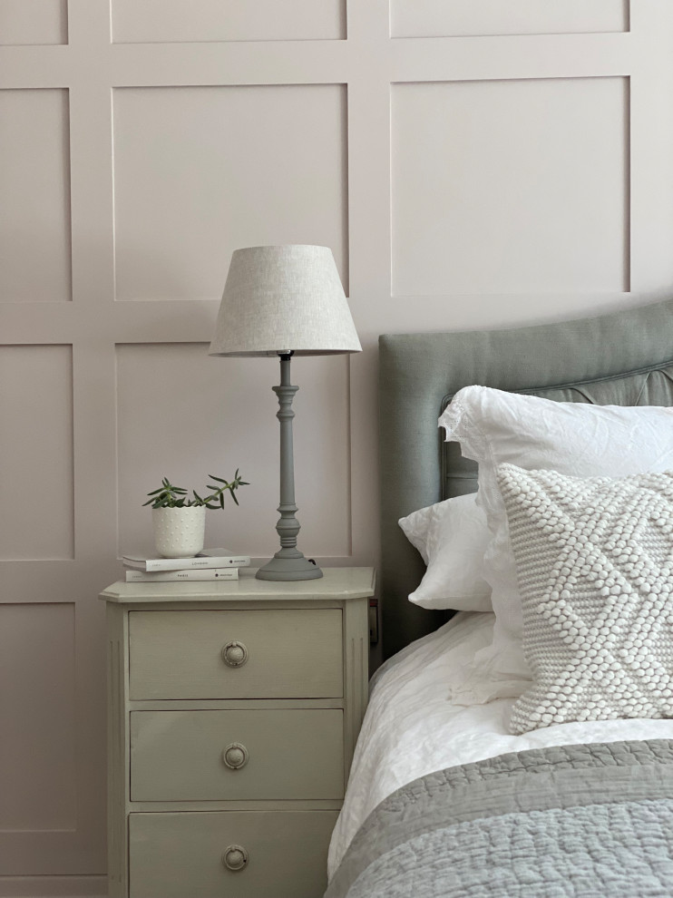 На фото: хозяйская спальня в стиле неоклассика (современная классика) с розовыми стенами, ковровым покрытием, бежевым полом и панелями на части стены с