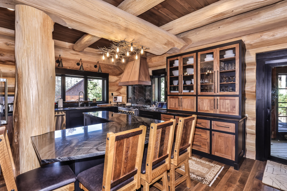 Inspiration for a rustic u-shaped dark wood floor, brown floor and exposed beam open concept kitchen remodel with an undermount sink, shaker cabinets, black cabinets, solid surface countertops, multicolored backsplash, stainless steel appliances, an island and multicolored countertops