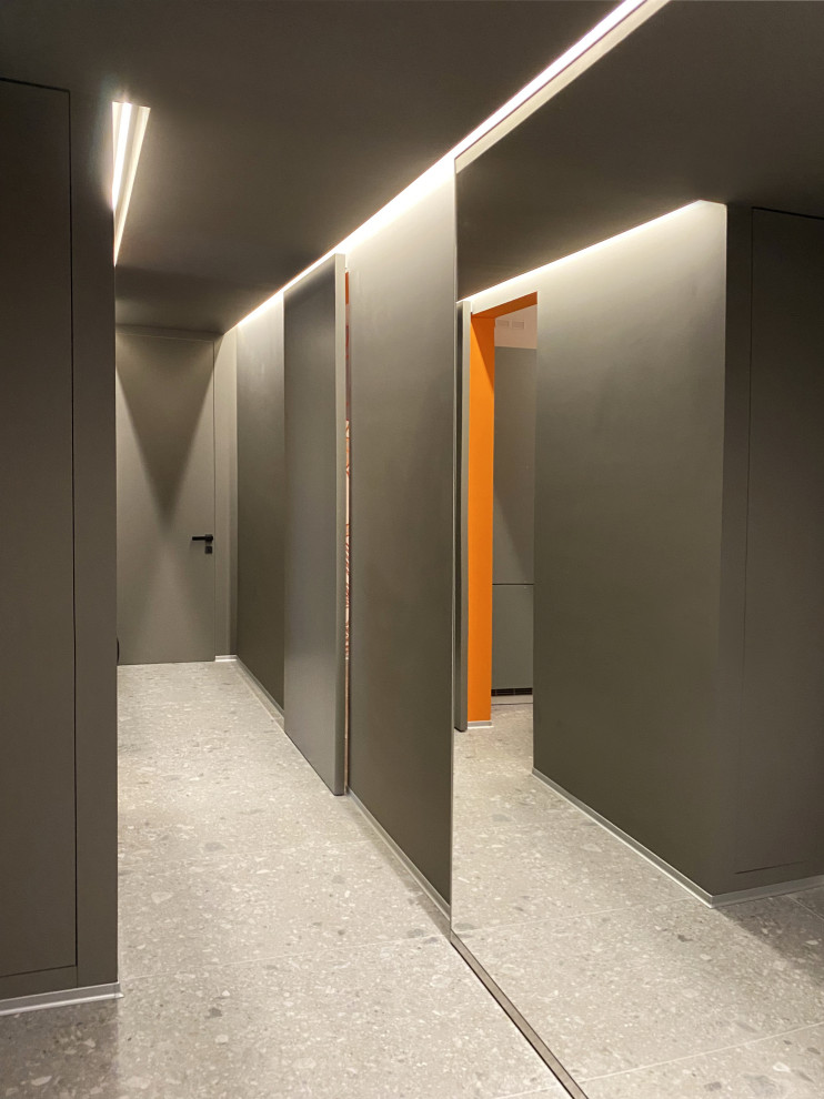 Réalisation d'un couloir design avec un mur gris, un sol en carrelage de porcelaine, un sol gris et un plafond décaissé.