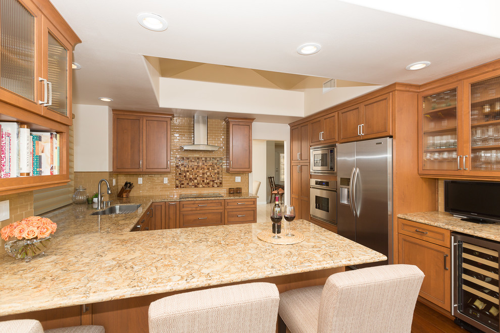 Large transitional u-shaped dark wood floor eat-in kitchen photo in Orange County with a single-bowl sink, raised-panel cabinets, medium tone wood cabinets, granite countertops, beige backsplash, ceramic backsplash, stainless steel appliances and no island