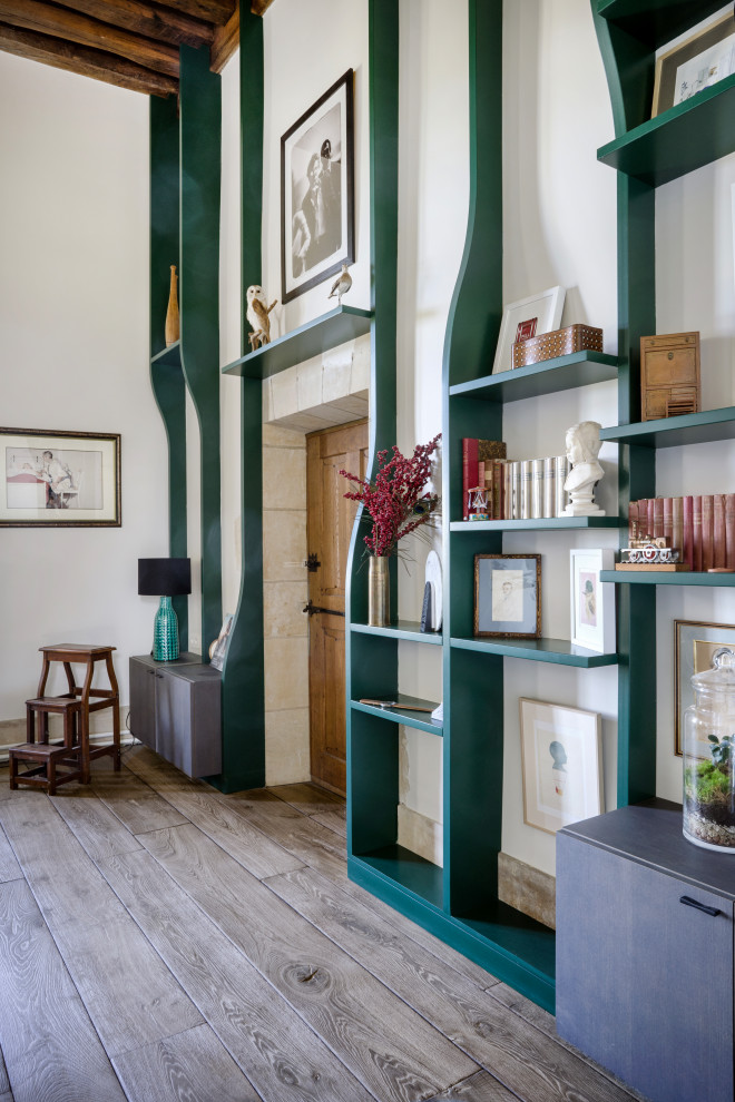 Idee per un soggiorno contemporaneo con libreria, pareti bianche, parquet chiaro, pavimento beige e travi a vista