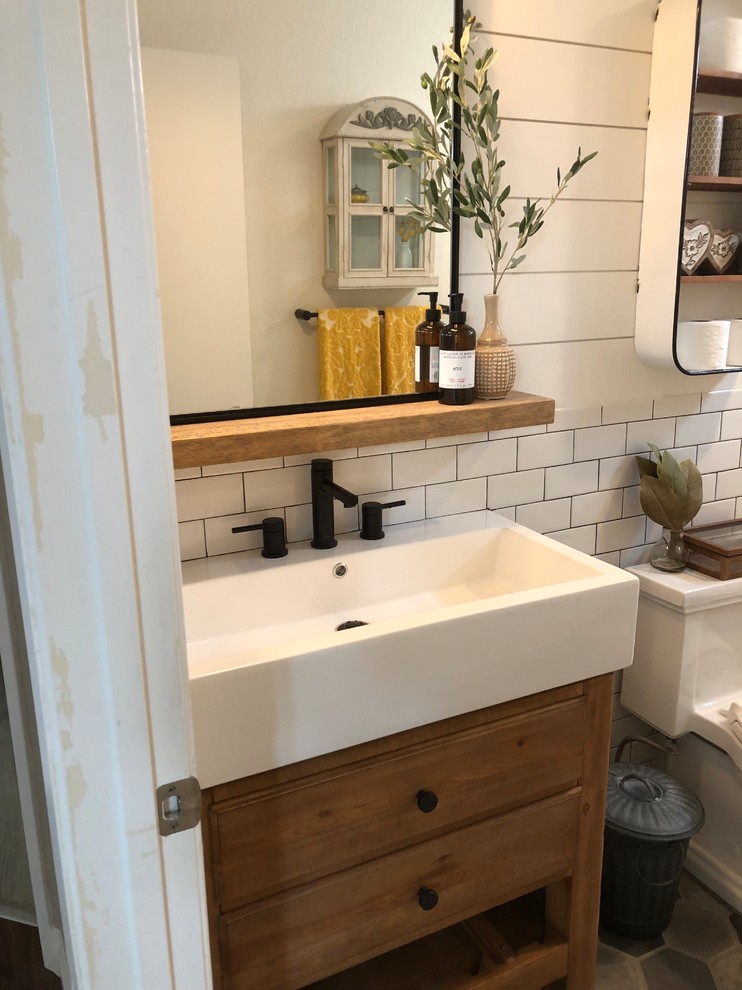 Photo of a mid-sized country kids bathroom in San Diego with furniture-like cabinets, distressed cabinets, a two-piece toilet, white tile, subway tile, white walls, ceramic floors, an integrated sink, engineered quartz benchtops, grey floor and white benchtops.