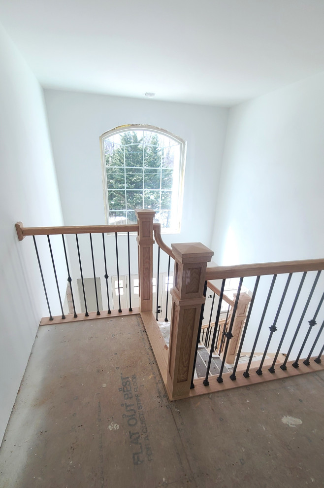 Exemple d'un grand escalier tendance en L avec des marches en travertin, des contremarches en bois et un garde-corps en matériaux mixtes.