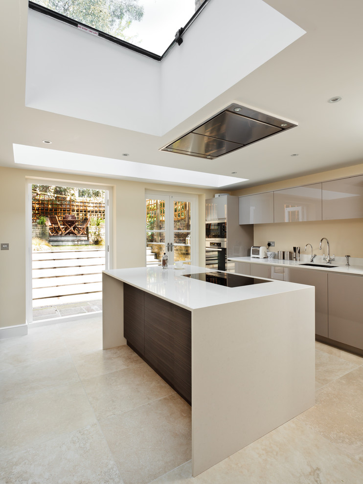 Mid-sized contemporary kitchen in London with solid surface benchtops, panelled appliances, ceramic floors and with island.