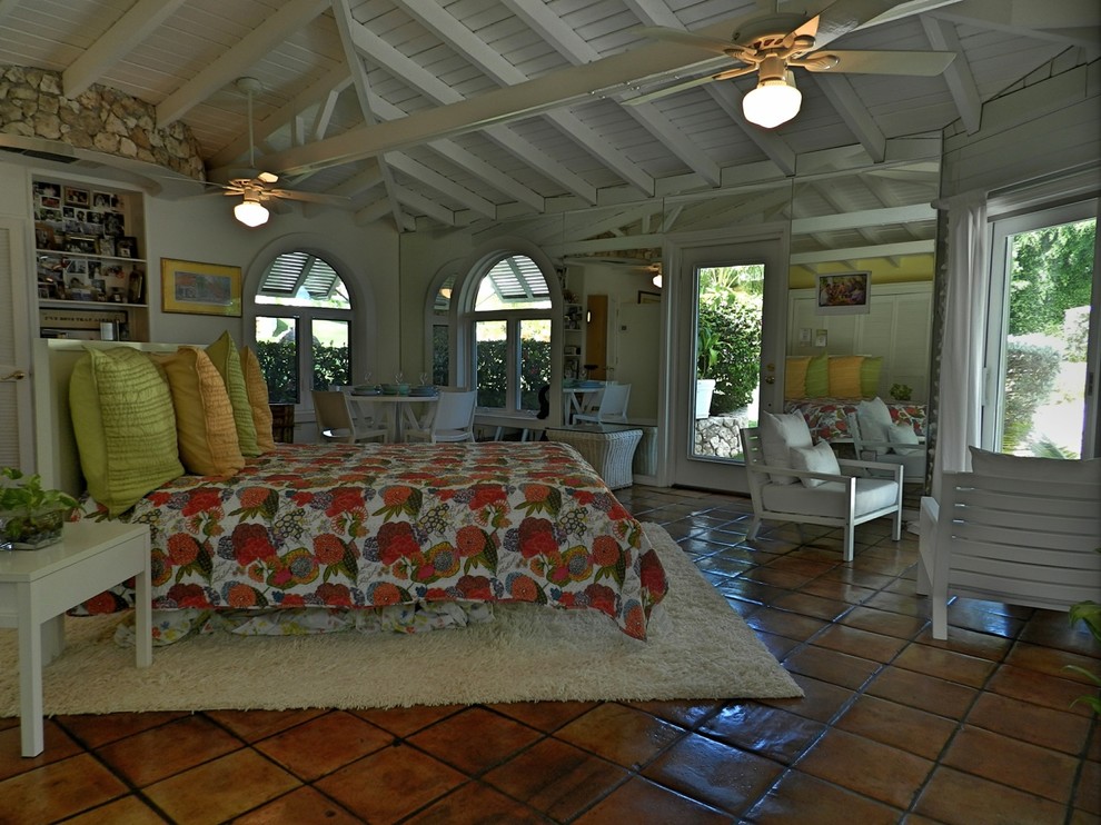 Photo of a tropical bedroom in Other with terra-cotta floors.