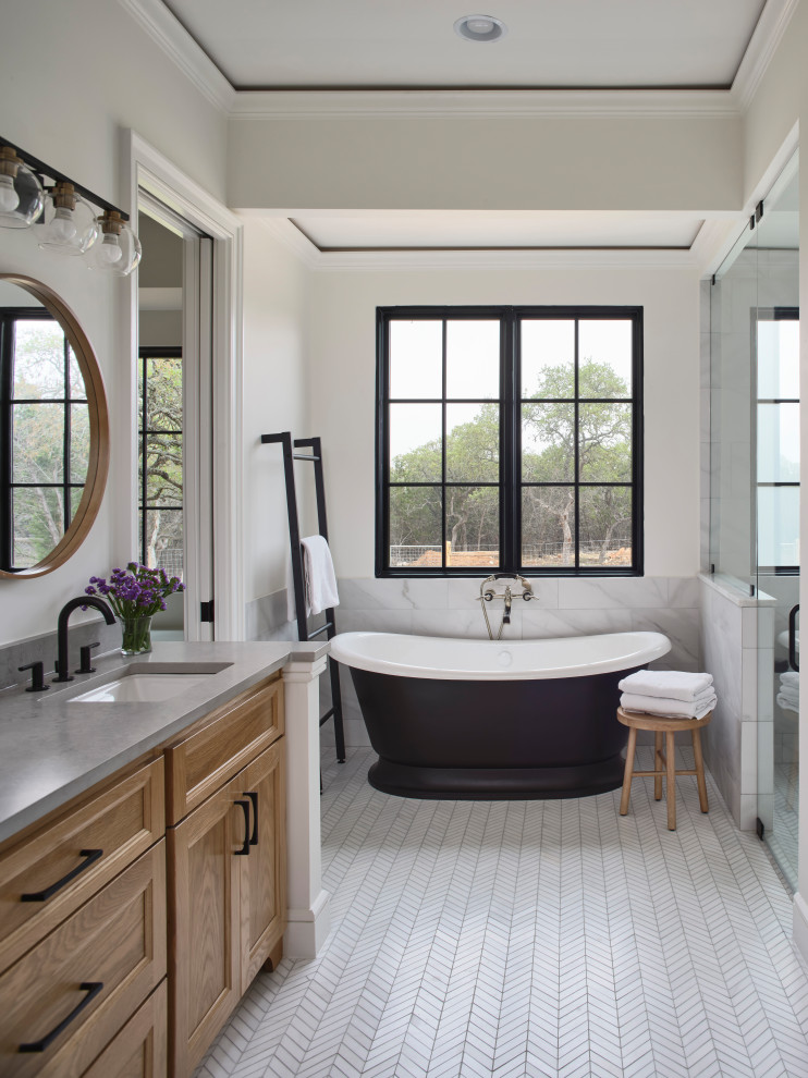 Maritim inredning av ett stort grå grått en-suite badrum, med skåp i ljust trä, ett fristående badkar, vit kakel, vita väggar, ett integrerad handfat, vitt golv och dusch med gångjärnsdörr