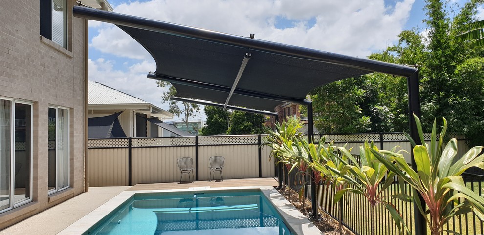 This is an example of a mid-sized modern backyard rectangular natural pool in Brisbane with decking.