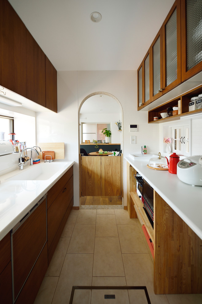 This is an example of a scandinavian galley separate kitchen in Other with an integrated sink, flat-panel cabinets, medium wood cabinets, white splashback, a peninsula and beige floor.