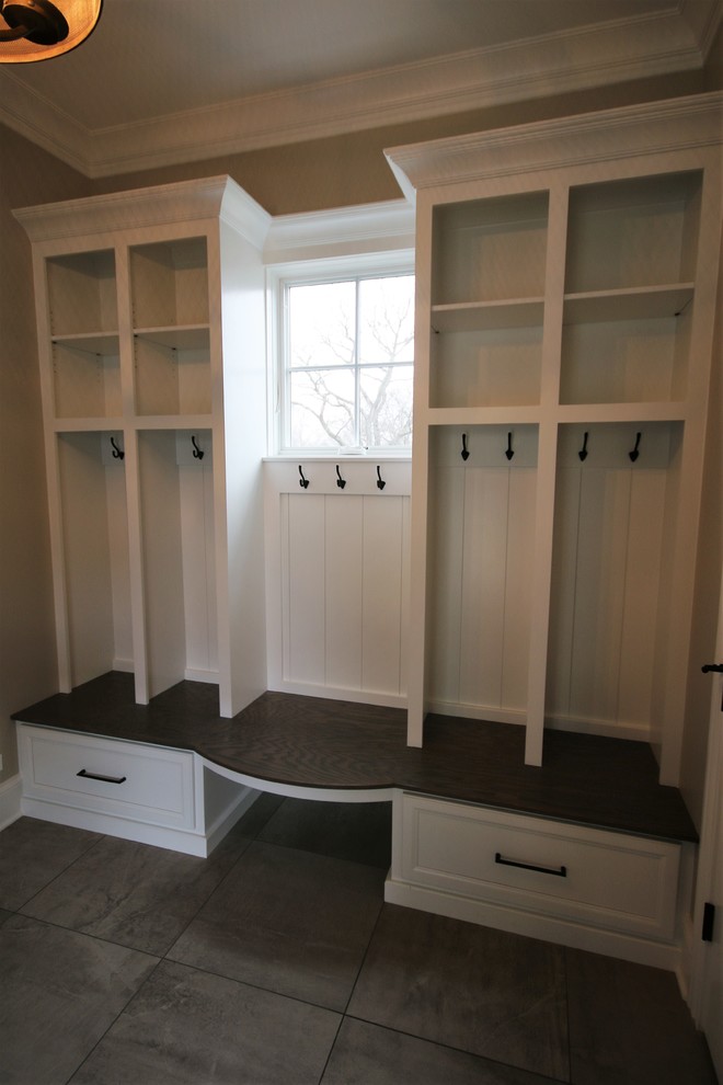Design ideas for a mid-sized transitional mudroom in Chicago with porcelain floors, beige walls, a single front door, a white front door and grey floor.