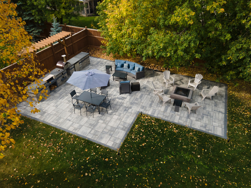 Inspiration pour une grande terrasse arrière design avec une cuisine d'été, des pavés en béton et une pergola.