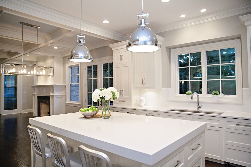 Mid-sized transitional single-wall slate floor enclosed kitchen photo in Chicago with an undermount sink, recessed-panel cabinets, dark wood cabinets, solid surface countertops, green backsplash, mosaic tile backsplash, stainless steel appliances and an island