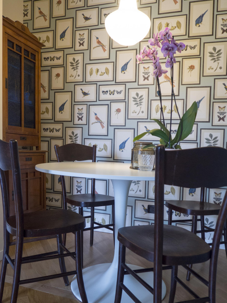 Photo of a small bohemian dining room in Milan with banquette seating, green walls and painted wood flooring.