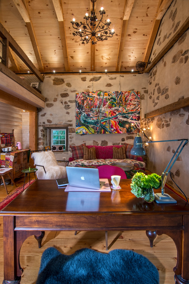 Mittelgroßes Shabby-Chic Arbeitszimmer mit Studio, beiger Wandfarbe, hellem Holzboden, freistehendem Schreibtisch, braunem Boden und freigelegten Dachbalken in New York