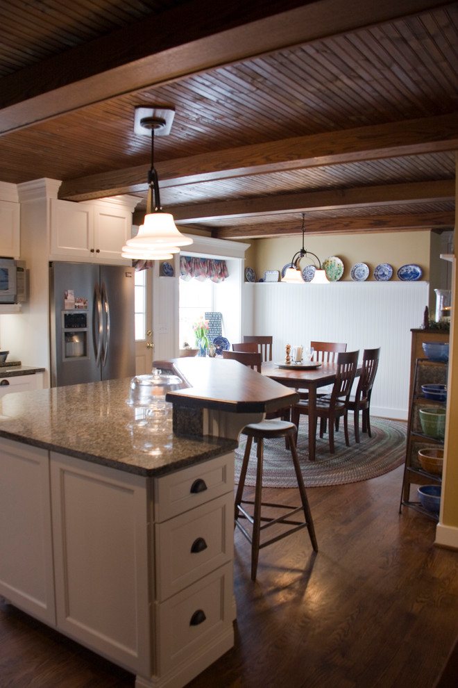 Inspiration for a mid-sized country l-shaped eat-in kitchen in Other with a farmhouse sink, shaker cabinets, white cabinets, granite benchtops, beige splashback, stone tile splashback, stainless steel appliances, medium hardwood floors and with island.