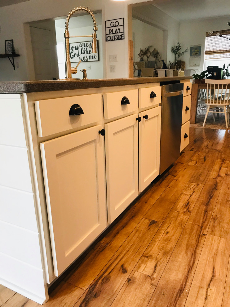 Example of a mid-sized trendy galley multicolored floor eat-in kitchen design in Other with shaker cabinets, white cabinets, quartzite countertops, white backsplash, ceramic backsplash, stainless steel appliances, an island and multicolored countertops