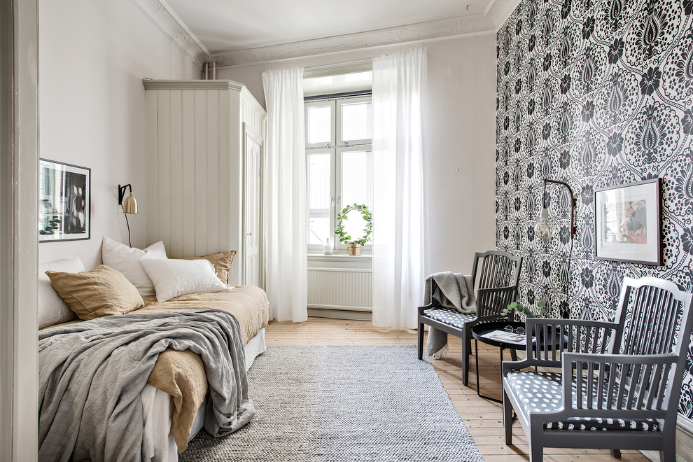 Design ideas for a mid-sized scandinavian guest bedroom in Gothenburg with multi-coloured walls, light hardwood floors and no fireplace.