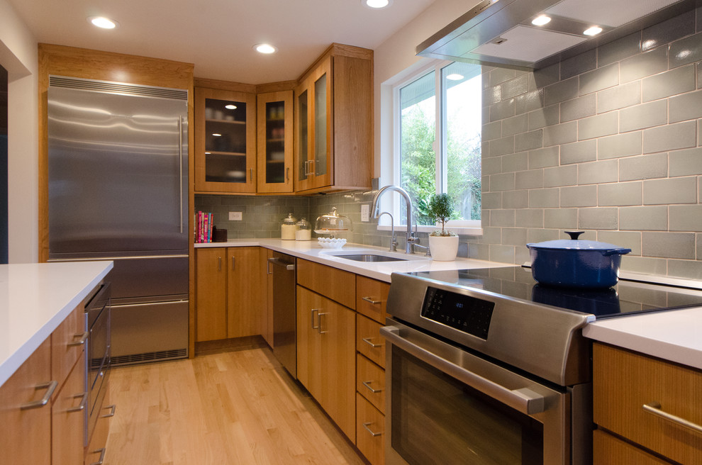 Kitchen - mid-sized transitional l-shaped light wood floor kitchen idea in Seattle with an undermount sink, flat-panel cabinets, medium tone wood cabinets, ceramic backsplash, stainless steel appliances and an island