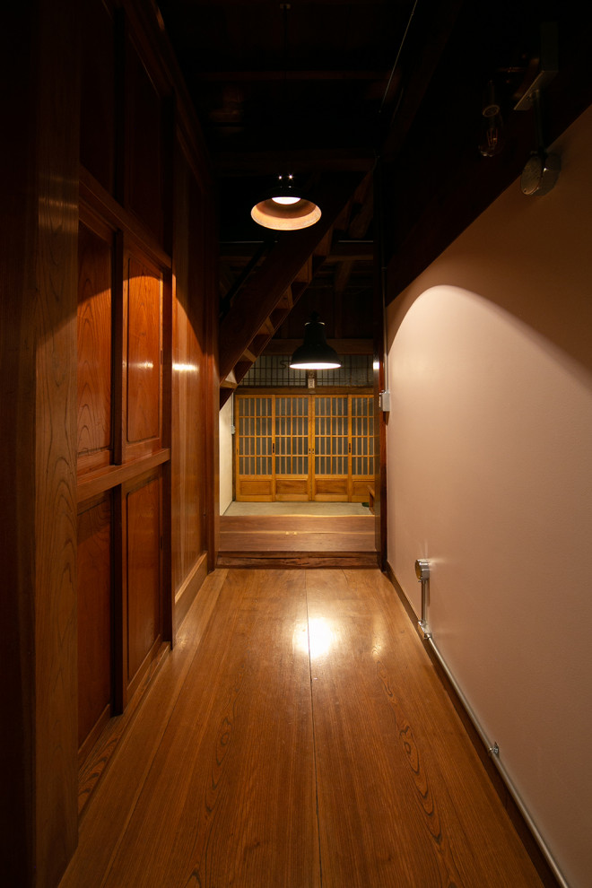 This is an example of a mid-sized contemporary hallway in Other with white walls, medium hardwood floors, beige floor and exposed beam.