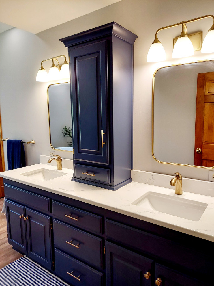 Bild på ett mellanstort funkis vit vitt en-suite badrum, med blå skåp, ett fristående badkar, vit kakel, vita väggar, vinylgolv, granitbänkskiva och beiget golv