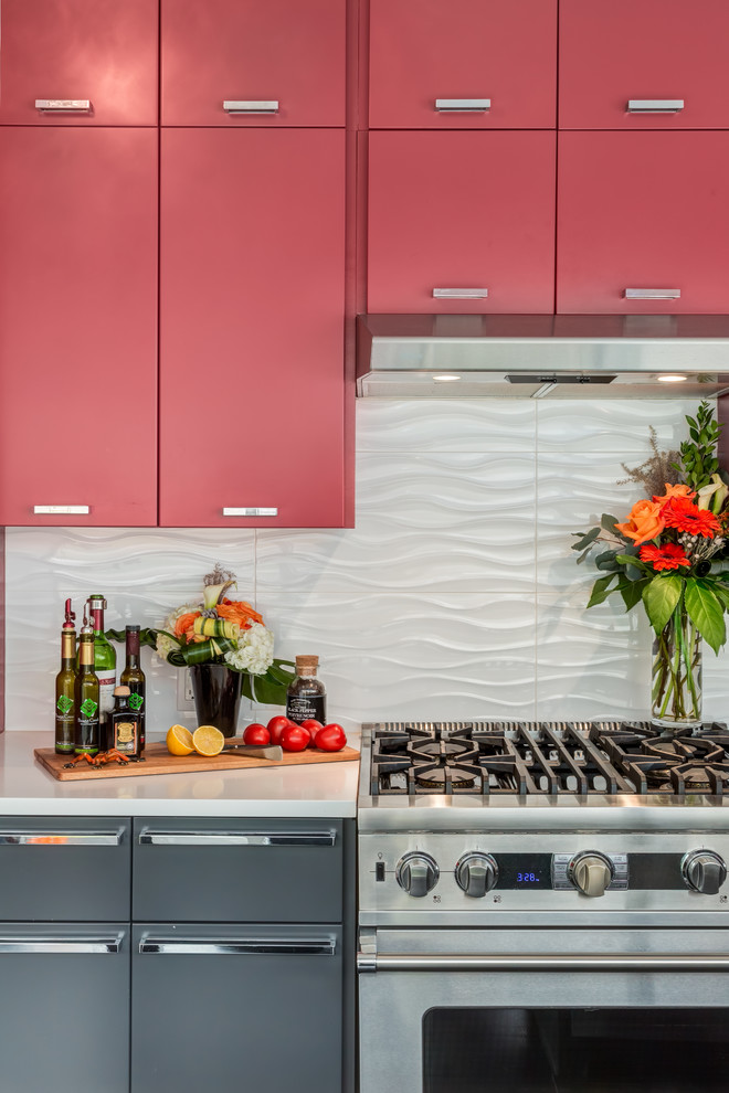 This is an example of a mid-sized modern separate kitchen in Calgary with white splashback, porcelain splashback, stainless steel appliances, with island, an undermount sink, flat-panel cabinets, red cabinets, quartz benchtops and porcelain floors.